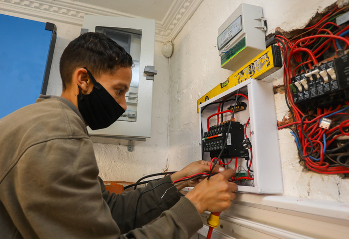 A female electrician busy installing a solar panel.